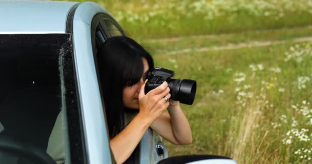 Donna fotografo seduto in macchina e fotografare un paesaggio campo di fiori - Filmati, video