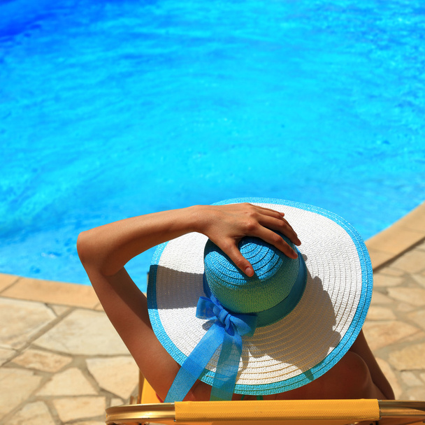 Mujer en sombrero junto a la piscina
 - Foto, imagen