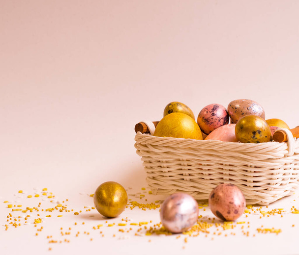 Easter holiday. Beautiful, mother-of-pearl eggs in a small basket lie on a uniform background. - Foto, Imagem