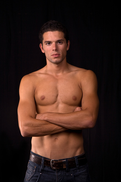 Young sensual man on a black background - Foto, imagen