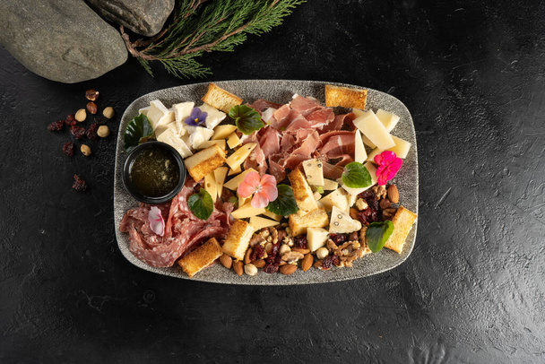 Plato to wine with cheese, sausage, ham, bacon, honey and nuts for a large company - Photo, Image