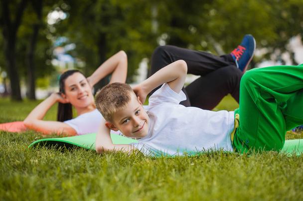 Son and mother doing exercises in the park - Foto, Bild