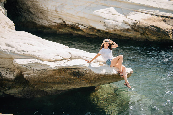 Gyönyörű lány rövidnadrágban és egy kalap a tenger mellett Cipruson - Fotó, kép