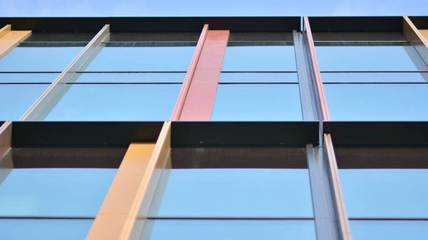 Egy irodaház üvegezett homlokzata tükrözött égbolttal. Modern építészeti épületek külső  - Fotó, kép