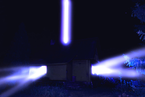 Bilim kurgu konsepti çizimi. Gecenin bir yarısı mavi ışıkla ıssız kır evini aydınlatan bir UFO. Renk atlatma etkisi. Resim gürültü ve tahıl içeriyor - Fotoğraf, Görsel