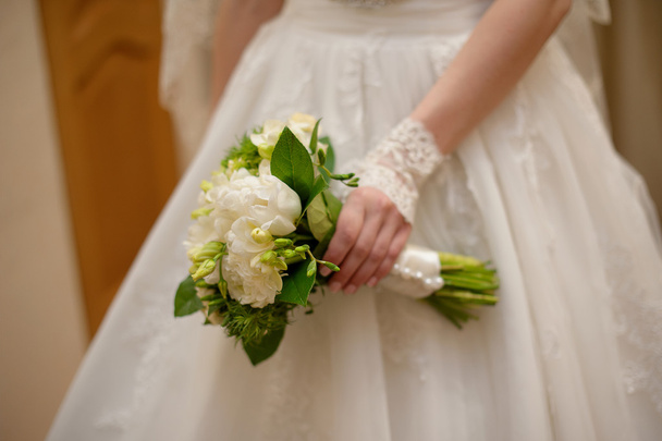 Νύφη κρατώντας λευκό γαμήλιο μπουκέτο με τριαντάφυλλα και λουλούδια αγάπης - Φωτογραφία, εικόνα