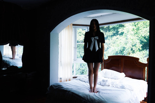 young woman in a black dress with a pillow on her bed - Foto, immagini