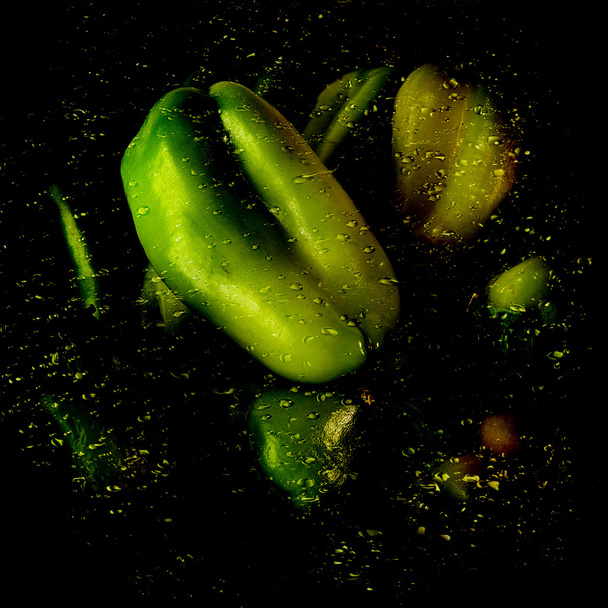Green pepper over wet shiny surface with water drops and splash on the original background with reflection - Photo, Image