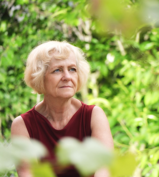 Mature, blonde woman in garden, - Valokuva, kuva