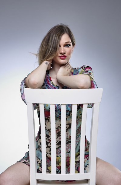 Menina bonita em uma cadeira
 - Foto, Imagem