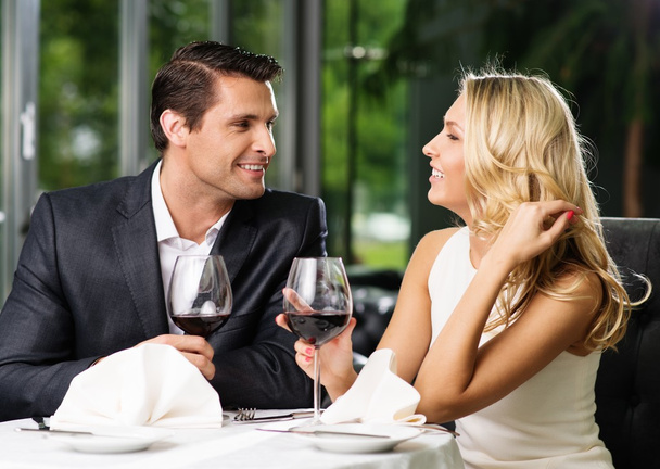 Cheerful couple in a restaurant with glasses of red wine - Photo, Image