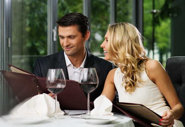 Cheerful couple with menu in a restaurant  - Photo, Image