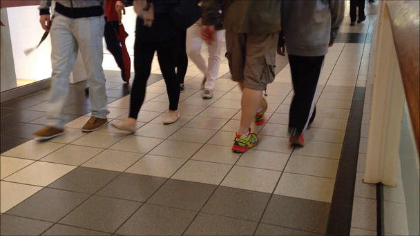 Käytävällä kävelevien ihmisten jalat
 - Materiaali, video