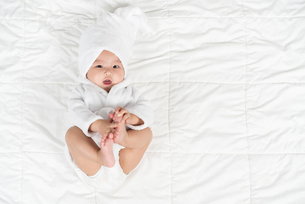 happy baby in soft bathrobe on a bed - Foto, immagini