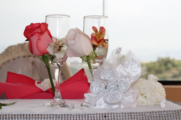 Copas de los recien casados en primer plano, decadas con flores cintas para el brindis. Kép ideális para promocionar decoraciones y menaje. - Fotó, kép