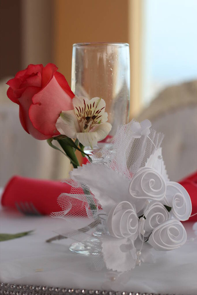 Copa de novia en primer plano, decorada con flores rojas y cintas blancas para el brindis de los recien casados. Wyobraź sobie idealny para promocionar decoraciones. - Zdjęcie, obraz