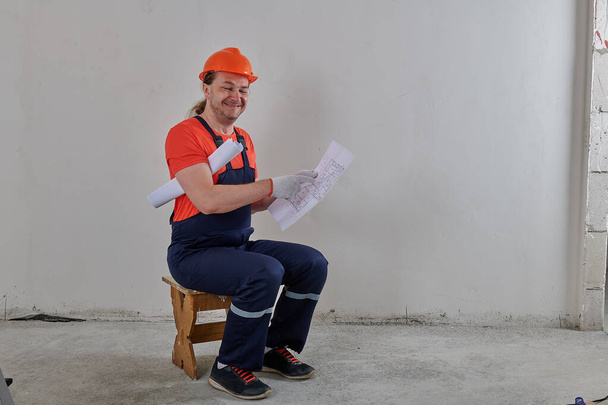 happy engineer sitting on a chair with drawings - Photo, Image