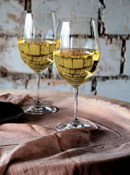 Droge witte wijn in glazen glazen op tafel. Vakantie setting voor twee - Foto, afbeelding