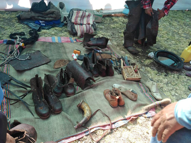 Botas, zapatos, cinturon, casacas y otros, hechos artesanalmente de cuero por un hombre que muestra su talento y arte, esto en una feria artesanal en Chumbivilcas - Cusco - Peru - Foto, Imagem