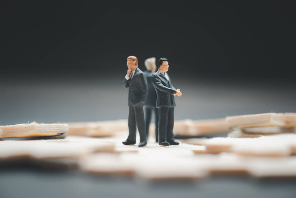 Miniature people : Group of businessman standing on jigsaw. Image use for to solve problems, finding solution and think new idea concept. - Photo, Image