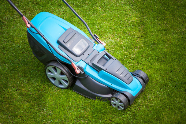 blue lawn mower on green grass - Photo, Image