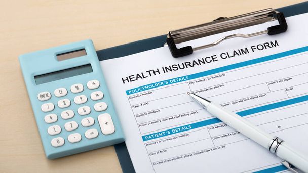 Formulario de reclamo de seguro de salud con calculadora y pluma - Foto, Imagen