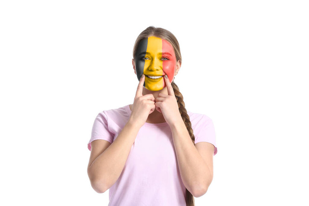 Joyeux jeune femme avec le visage dans les couleurs du drapeau belge sur fond blanc - Photo, image