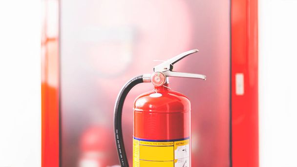 El extintor rojo está listo para su uso en caso de una emergencia de incendio en interiores. - Foto, Imagen