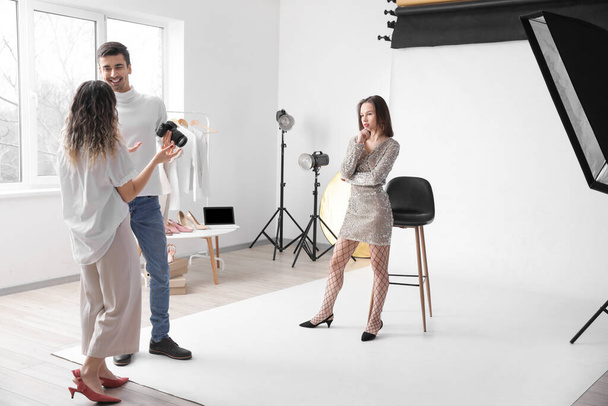 Stylist and photographer working with model in studio - Foto, imagen