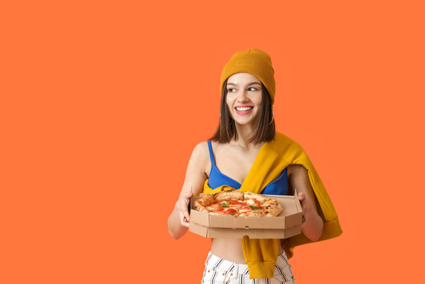 色の背景においしいピザと美しい女性 - 写真・画像