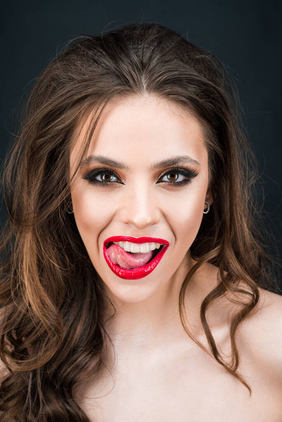 Sensual woman open mouth, tongue touches the teeth. Close-up licking sexy red lips. - 写真・画像