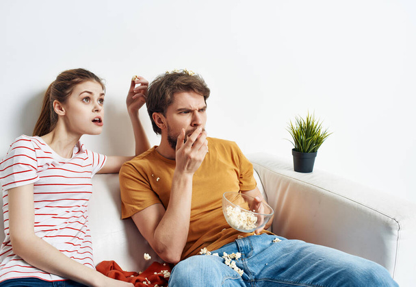 άνδρας και γυναίκα στο σπίτι στον καναπέ βλέποντας τηλεόραση ποπ κορν ψυχαγωγία - Φωτογραφία, εικόνα