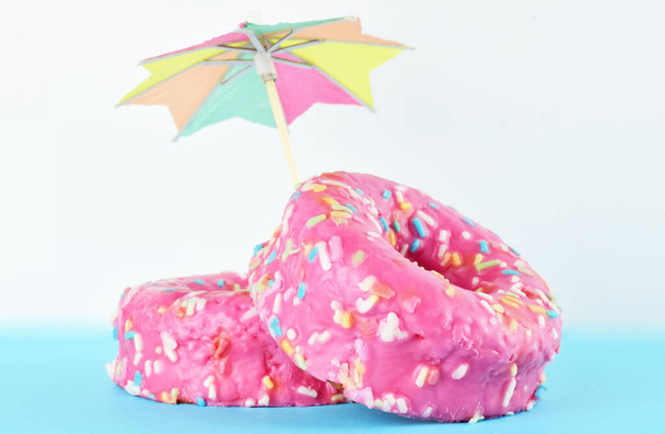 Vooraanzicht. Donuts met chocolade en gekleurde noedels. Onderkant en onderkant, twee kleuren. - Foto, afbeelding