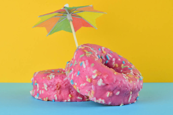 Vista frontal. Donuts com chocolate e macarrão colorido. Fundo e base, duas cores. - Foto, Imagem