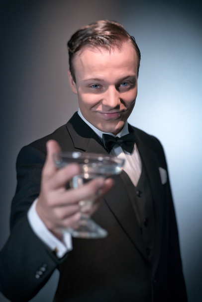χαμογελώντας ρετρό 1920 επιχείρηση μόδας άνθρωπος που κρατά ποτήρι σαμπάνιας. - Φωτογραφία, εικόνα