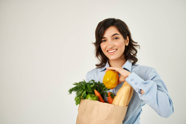mujer en paquete de camisa azul con comestibles alimentos saludables fondo claro - Foto, imagen