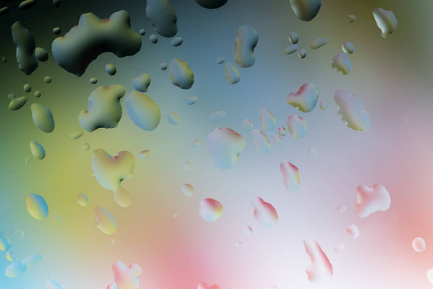 Абстрактное изображение капель воды на стеклянной поверхности, отражающейся на многоцветном фоне. - Фото, изображение