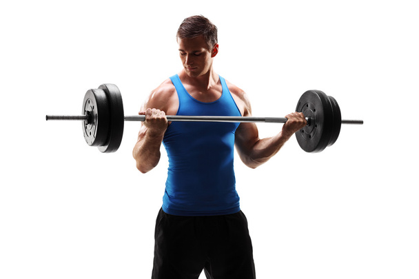 Muscular man exercising with barbell - Фото, зображення