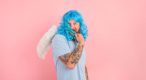 hombre con barba y azul peruke actúa como un agel con alas - Foto, imagen