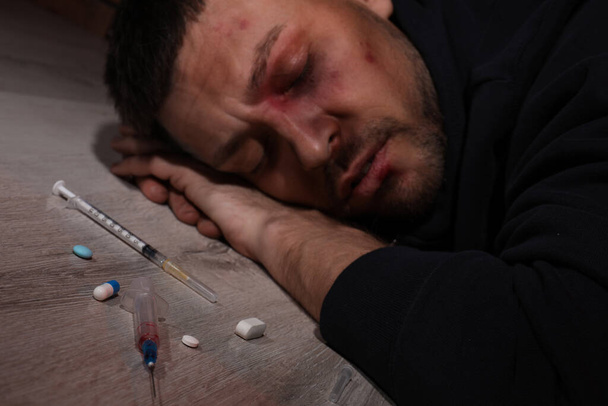Overdosed man indoors, focus on different drugs - Fotoğraf, Görsel