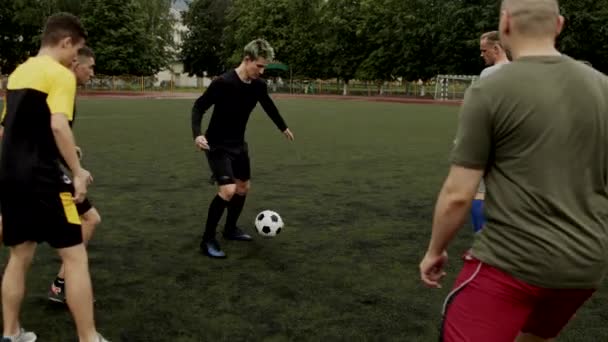 Futbol takımı oyuncuları stadyumda antrenman yapıyor ve kendi aralarında futbol oynuyorlar. Yavaş çekim - Video, Çekim