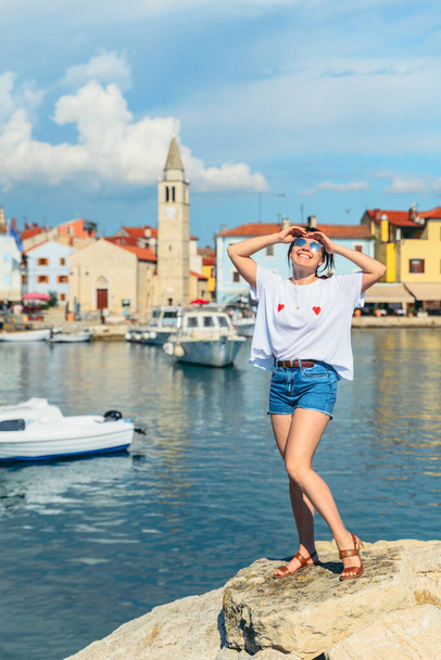 young pretty smiling woman standing at beach Fazana city on background. Croatia - Foto, afbeelding