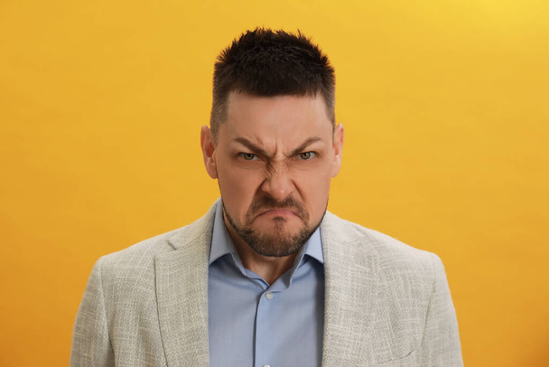 Angry man on yellow background. Hate concept - Zdjęcie, obraz