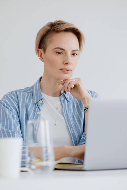 confident woman with a laptop in the home office works online or shopping - Fotografie, Obrázek