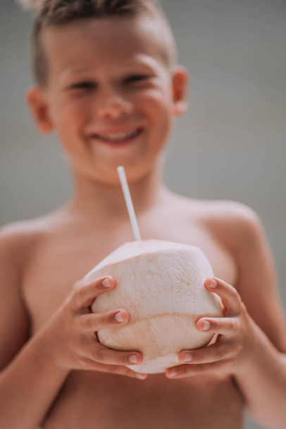 roztomilý malý chlapec pití kokosové šťávy v létě  - Fotografie, Obrázek