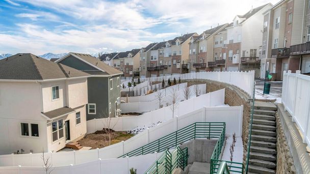 Pano Snowy neighborhood landscape with stairs and road amid homes and townhouses - Photo, Image