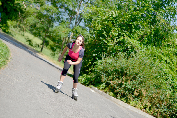 mooie jonge vrouw doen Rolschaaten op een track - Foto, afbeelding