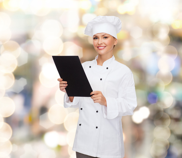 smiling female chef with black blank paper - Foto, Imagen