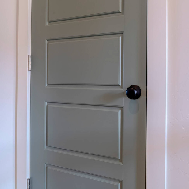 Marco cuadrado Interior de la casa con vista de cerca de la puerta del dormitorio gris con perilla de puerta negra - Foto, imagen