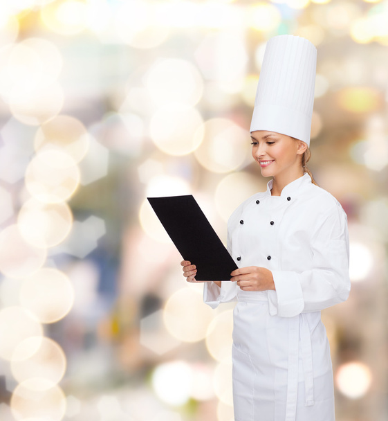 smiling female chef with black blank paper - Zdjęcie, obraz
